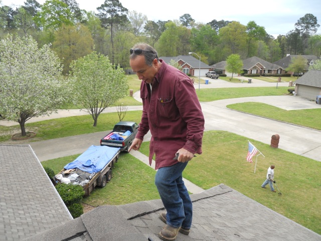 Picture from rooftop of Grumbles team member inspecting a roof