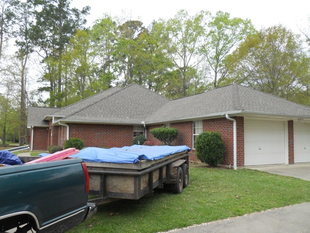 Front of house picture of a roll-off truck bed parked in front of home